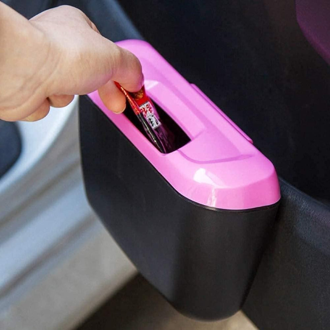 Pink and black car trash can with a hand disposing of a small item.