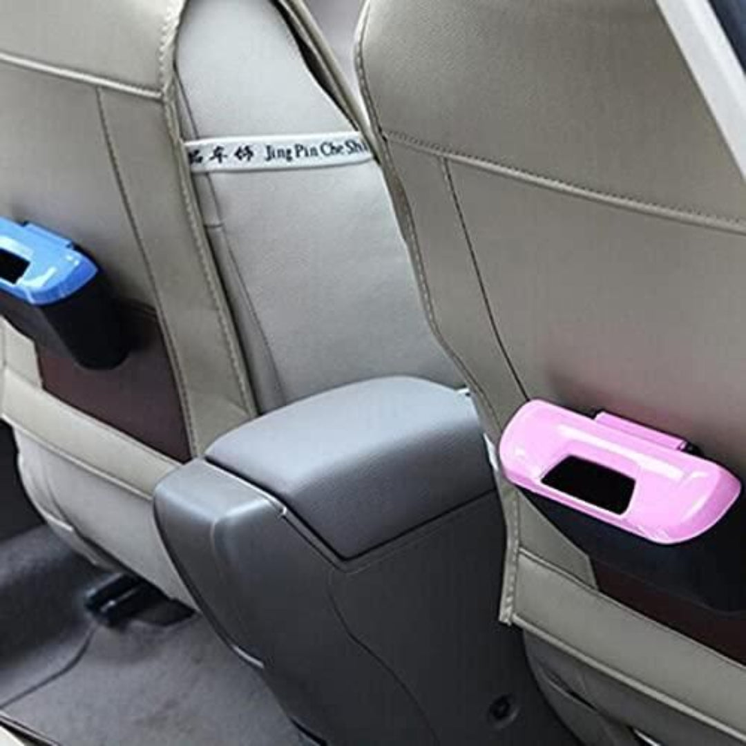 Car interior with a pink cup holder and black trash can attached to the armrest.